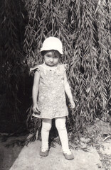 Vintage photo of little girl near willow tree