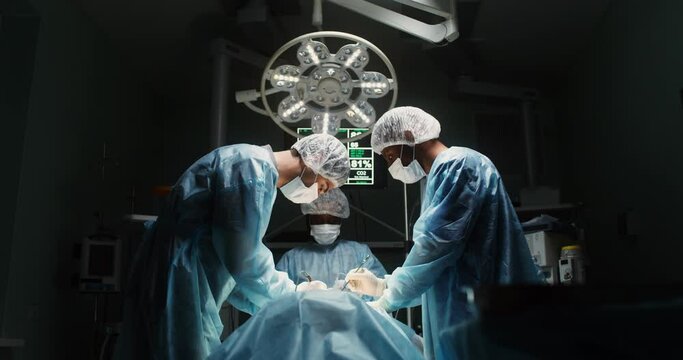 A team of surgeons perform an operation in a bright operating room