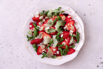 Salad with strawberries, basil sprouts, cheese and almonds