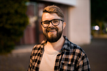 Portrait of man standing in night city street with bokeh street lights in background. Confident lonely guy. Close-up portrait