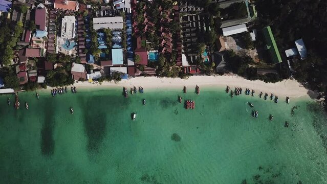 Aerial Top view Longtail fishing boats and village in the tropical sea at phi phi island beach Thailand Beautiful sea surface