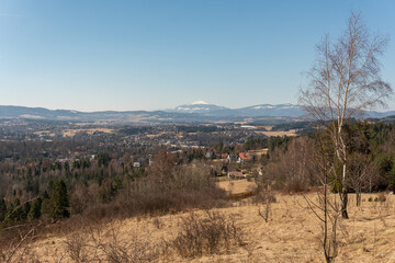 Naklejka premium Breathtaking view on amazing snowy mountains and hills in spring, forest and village, panoramic landscape 