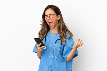 Young surgeon doctor woman over isolated white wall with phone in victory position