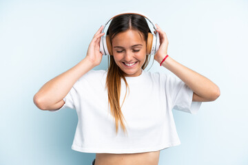 Naklejka premium Young caucasian woman isolated on blue background listening music