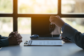 Close up of hands. Sale-man is selling and buying a car with loan agreement and financial between client.