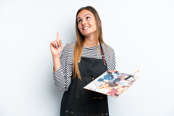Young artist caucasian woman holding a palette isolated on white background pointing up a great idea