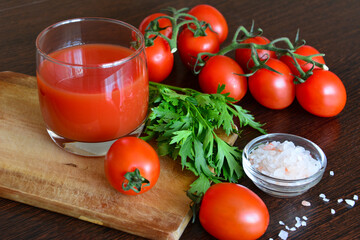fresh cherry tomatoes with parsley and salt on cutting board, close-up