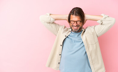 Senior dutch man isolated on pink background frustrated and covering ears