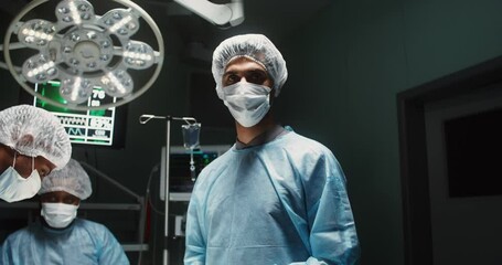 A team of surgeons perform an operation in a bright operating room