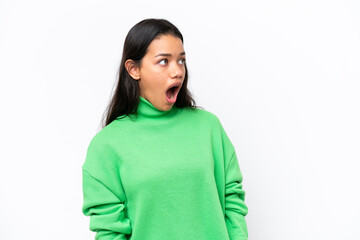 Young Colombian woman isolated on white background doing surprise gesture while looking to the side