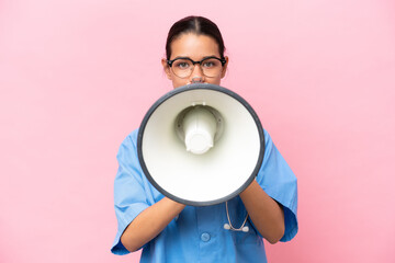 Young nurse Colombian woman isolated on pink background shouting through a megaphone