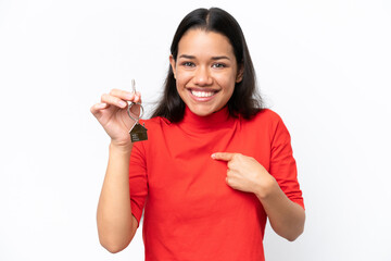 Young Colombian woman holding home keys isolated on white background with surprise facial expression