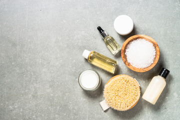 Spa background. Spa product composition with palm leaves, towel and cosmetic at stone table. Flat lay image with copy space.