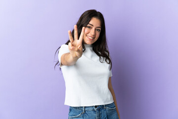 Young caucasian woman isolated on purple background happy and counting three with fingers