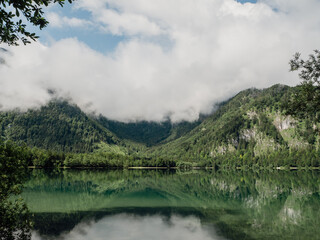 foggy morning above the lake in the mountains with crystal clear water like a mirror