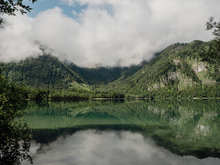 foggy morning above the lake in the mountains with crystal clear water like a mirror