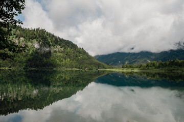 foggy morning above the lake in the mountains with crystal clear water like a mirror