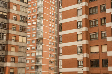 Facades of buildings made with red bricks. Windows. Architecture. Demography. Overlopulation. Urban hives