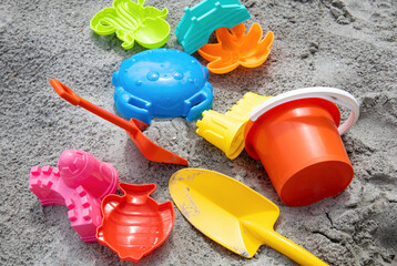 Fototapeta na wymiar Children toys: bucker, shovel, sand molds lie on the sand. Children's beach sand toys.