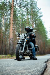 Fototapeta premium Young couple in black leather clothes on a vintage motorcycle.