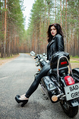 Plakat A girl in tight black leather sits on a motorcycle.