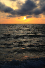 Obraz premium dark rainy cumulous clouds and epic sunset on the beach