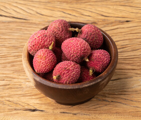 Lychees in a bowl over wooden table