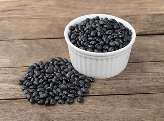 Fototapeta na wymiar Black beans in a bowl over wooden table