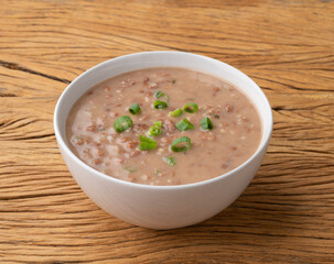 Brown bean soup in a bowl over wooden table