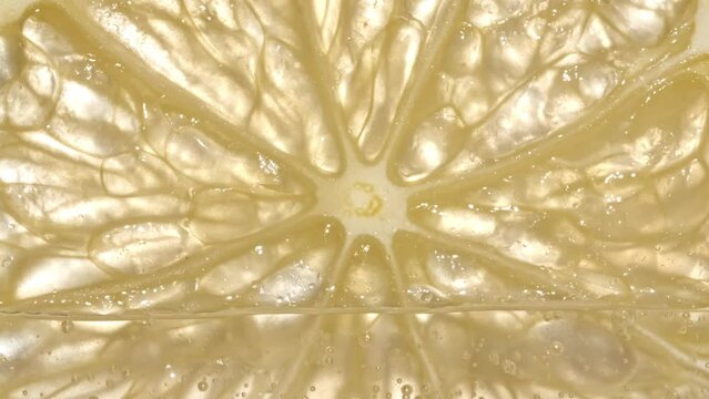 Water with Lemon Slices and exploding soda, air bubbles. Refreshing soft drink Lemon and sparkling water with ice. Macro shot. High quality 4k footage