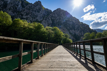 Wooden walkway over the lake next to the mountains is Asturias.