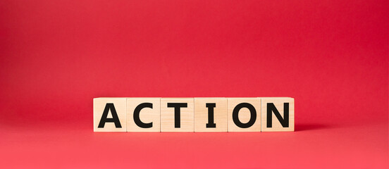 Action symbol. Concept word Action on wooden cubes. Beautiful red background. Business and Action concept. Copy space.