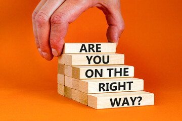 Right track symbol. Concept words Are you on the right track on wooden blocks on a beautiful grey table orange background. Businessman hand. Business motivational and right track concept.