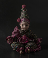 Amazing realistic porcelain doll, toy, harlequin, selective focusб vintage concept