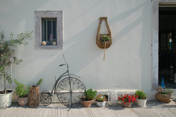 Fototapeta na wymiar Old bicycle and other decorations on white wall of house at Paxos in Greece