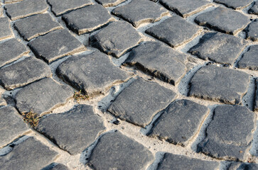 Old road made of paving stones. Selective focus