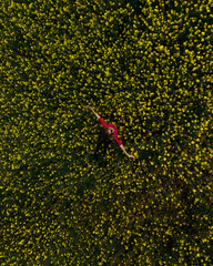 a girl in a red dress in a field with yellow flowers