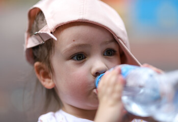 a small child drinks from a bottle