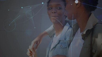 Animation of connections over happy african american twins women walking and embracing - Powered by Adobe