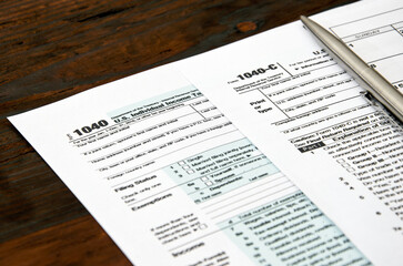 1040 US individual tax form and pen on wooden desc