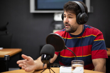 Young caucasian man during live broadcast of a radio programme. Space for text.
