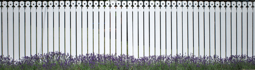 Panoramic photo of a white wooden fence.