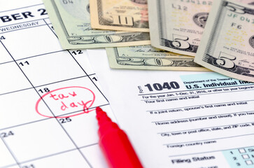 1040 individual tax form, money, calculator and red marker. Tax day. Business concept