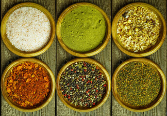 Spices and seasonings on a wooden table salt, pepper, za'atar, thyme, paprika. rustic style top view