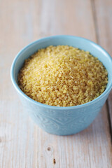 Dry uncooked bulgur in a ceramic bowl