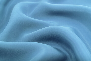 Obraz premium A piece of material with blue or turquoise folds. Silk fabric with oxen and rumples