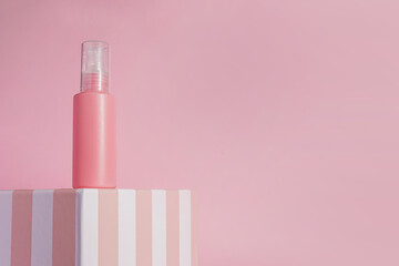 Mockup of pink container for cosmetics, cream, serum, gel standing on the podium on light...