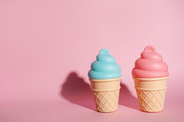 Ice cream toys made from plastic on pink background with copy space
