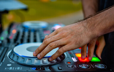 DJ Hands creating and regulating music on dj console mixer in concert outdoor
