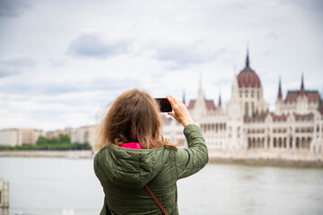 Fototapeta premium beautiful woman tourist in Budapest parliament building in background